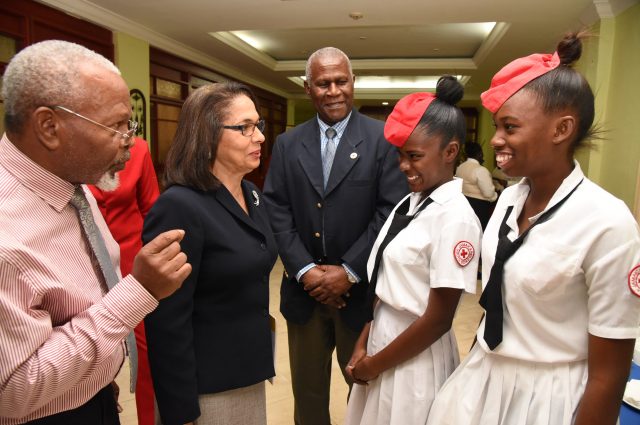 Minister of Labour and Social Security, Hon. Shahine Robinson (second left); Chairman, Jamaica Red Cross 70th Anniversary Committee, Silvera Castro (left); and President, Jamaica Red Cross, Dr. Dennis Edwards (centre), interact with students of Bridgeport High School, Kadian Smith (second right) and Natasha Morrison, during the media launch of the Jamaica Red Cross 70th Anniversary celebration, at The Knutsford Court Hotel in New Kingston on February 16.